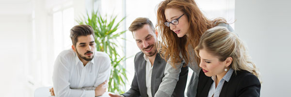 Avales y Garantias - Personas de traje sentados en una mesa en una reunion de equipo revisando papeles en una reunion de negocios