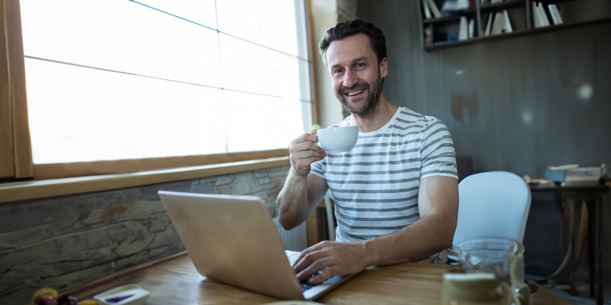 Planes de Pensiones Autónomos - Chico sonriente observando un portátil