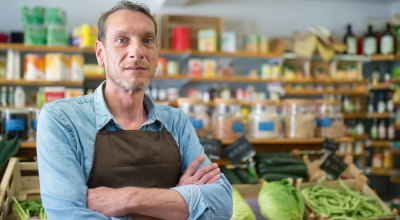 Vendedor de una frutería mirando a cámara