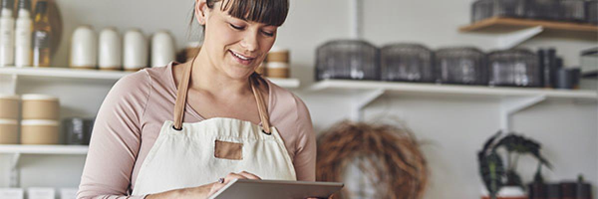 Cuenta Negocio Autónomos - Una mujer joven, florista, usando una tableta digital Cuenta Negocio Autónomos - Una mujer joven, florista, usando una tableta digital
