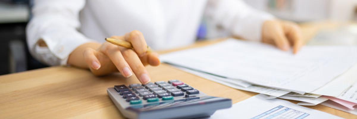 Anticipo de devolución IVA mensual - Mujer con calculadora y documentos