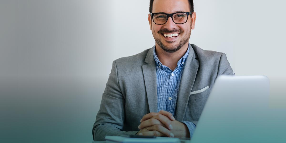 Préstamo estudios-chico sonriente delante de un portátil